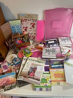 Overall view of scrapbook paper pads, magazines, utensils, adhesives and storage case