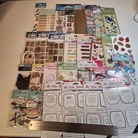 Full lot overview showing quantity and variety of sticker packs with ruler for scale