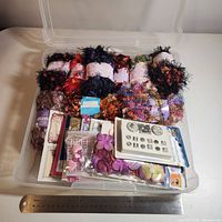 Bin showing yarn skeins, sticker packs and petals