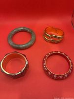 All four bracelets arranged on red background