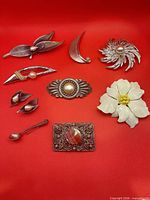 Front view of all brooches and earrings on red background