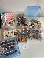 overview of plastic bins with washi tapes, stickers, tags, embellishments and bead cases