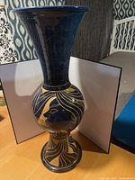 Full view of tall blue ceramic vase with gold design