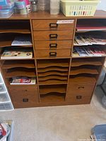 full view of wooden craft cabinet with drawers, shelves, paper and baskets