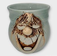 front view showing sculpted face design on mug