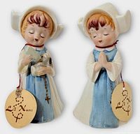 Front view of both Lil Nuns figurines with tags visible