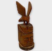 Full view of carved wood totem pole front angle