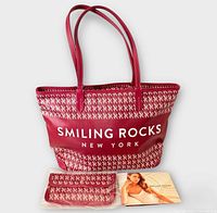 Front view of red Smiling Rocks tote, wristlet and booklet