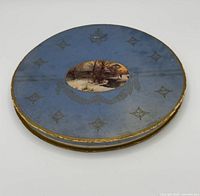 Top view of blue round Opal handkerchief box showing winter scene and decorative gilt motifs
