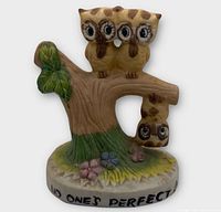 Front view of ceramic owl figurine showing three owls and inscription on base