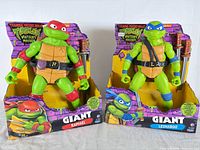 Front view of Raphael and Leonardo figures in open boxes with accessories visible