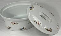 Casserole with lid off showing interior and floral exterior