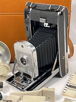 Camera extended with bellows alongside leather case