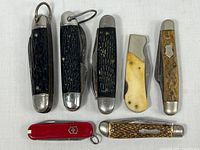 All seven knives arranged closed to show handles and condition