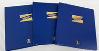 Three blue USPS Commemorative Stamp Club binders closed, front covers visible
