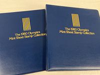 Front covers of the two identical blue binders with title text