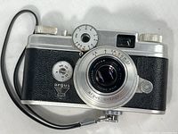 Front view of Argus C-Four camera with lens and attached cable release