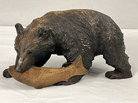 Full view of carved wooden bear holding fish