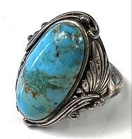Front perspective of ring showing turquoise stone and silver leaf motif
