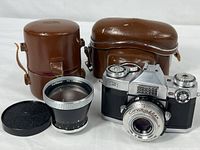 Camera, auxiliary lens, lens cap, two leather cases overview