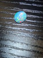 Front view of oval opal showing pinfire play-of-color