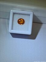 Loose orange garnet in display box
