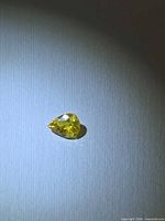 Pear-cut yellow sapphire front view on white background