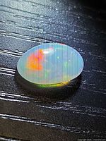Top view of oval crystal opal showing red and yellow fire