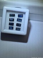 Eight blue baguette-cut sapphires shown in display box, front view