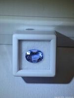 Front view of oval fluorite in display box