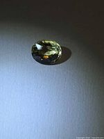 Oval golden scapolite on neutral background, showing color and cut