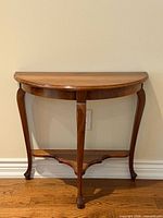 Front view of solid walnut demi-lune side table with lower shelf and cabriole legs