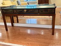 Full view of Drexel black lacquered console table with glass top