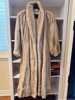 Front view of full-length blonde mink coat on hanger
