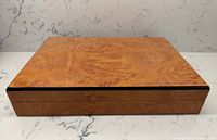 Top view of closed burl wood humidor showing grain and black trim