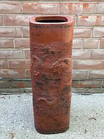 Full view of cylindrical terracotta umbrella stand
