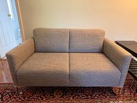 Front view of grey tweed loveseat