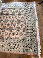 Overall view of Bokhara carpet on floor showing pattern and fringe
