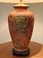 Profile of lamp base highlighting terracotta coloration and wooden plinth