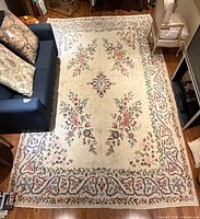 Full overhead view of entire cream floral rug placed under furniture