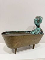 Full view of bronze woman in tub sculpture showing patina and tapered legs