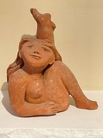 Front view of signed terracotta reclining female sculpture