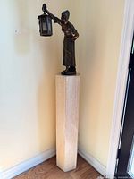 Full view of travertine pedestal standing in corner