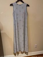 Full view of pale blue floral silk sleeveless dress on hanger
