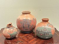 Front view of the three signed terracotta vessels