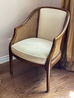 Front view of vintage cane-back barrel accent chair