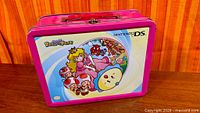 Front view of lunchbox showing artwork, frame, handle