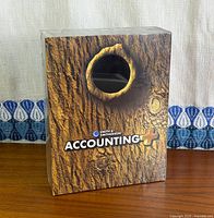 Front of sealed Accounting+ Best Buy Variant box with wood-grain artwork and window