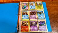 open binder showing nine Pokémon cards in sleeves