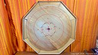 Full view of the octagonal wooden Crokinole board showing overall design and condition
